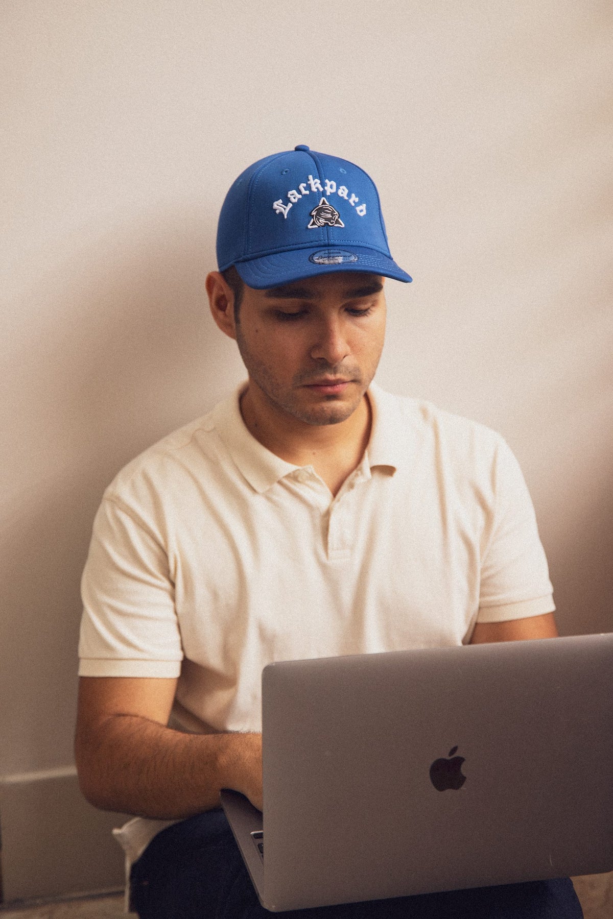 Model wearing a royal blue cap with raised 3D Lackpard embroidery
