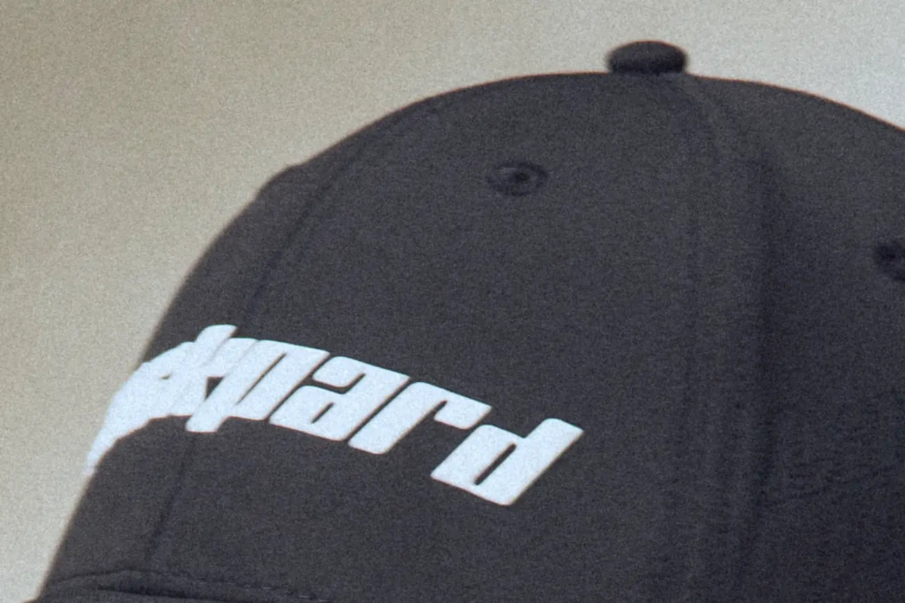 Close view of the raised white Lackpard wordmark on a black cap.